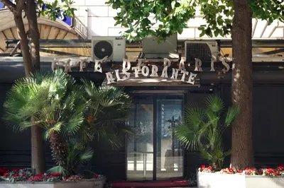 a sign on the front of a building with palm trees at Caterina One o One - Embassy Apartment in Rome