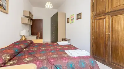 a bedroom with a bed and a wooden cabinet at Caterina One o One - Embassy Apartment in Rome