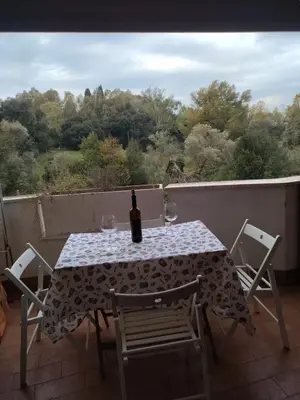 a table with a bottle of wine and chairs on a balcony at La Casa Vicino a Tutto in Rome