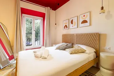 a bedroom with a large bed with pink sheets at DomusFebo SanGiovanniSuites in Rome