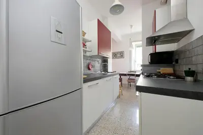 a kitchen with white cabinets and a black counter top at Silvano's Home In Rome in Rome
