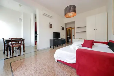 a bedroom with a red bed and a living room at Silvano's Home In Rome in Rome