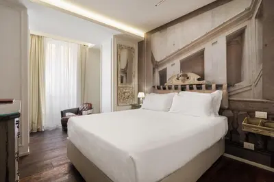 a bedroom with a large white bed and a chair at BDB Rooms Trastevere in Rome