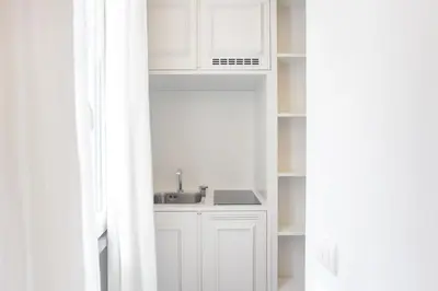 a kitchen with white cabinets and a sink at BDB Rooms Trastevere in Rome