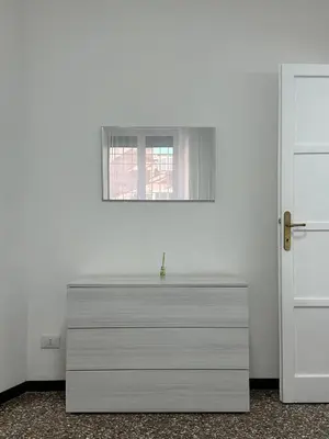 a white dresser in a room with a window at Cozy House Roma - San Giovanni in Rome