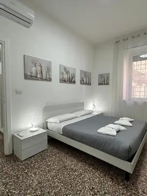 a white bedroom with a bed and a window at Cozy House Roma - San Giovanni in Rome