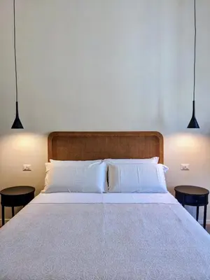 a bedroom with a large bed with two tables at Peaceful Roman Retreat in Rome