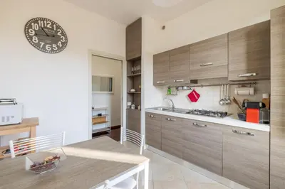 a kitchen with wooden cabinets and a clock on the wall at Attico vista San Pietro, vicino ai Musei Vaticani in Rome