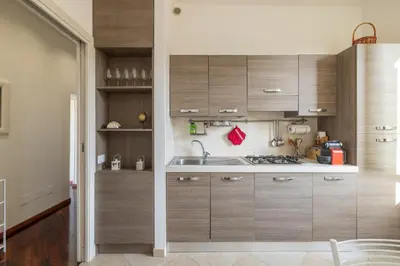 a kitchen with wooden cabinets and a sink at Attico vista San Pietro, vicino ai Musei Vaticani in Rome