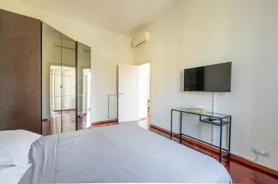 a bedroom with a white bed and a flat screen tv at Attico vista San Pietro, vicino ai Musei Vaticani in Rome