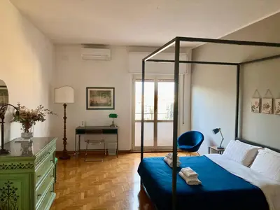 a bedroom with a canopy bed with a desk and a chair at Spazioso Appartamento Vicino al Vaticano in Rome