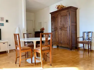 a dining room with a table and chairs and a wooden cabinet at Spazioso Appartamento Vicino al Vaticano in Rome