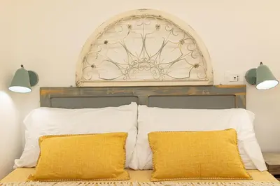 a bed with a headboard and two pillows on it at Khris Home Apartments - Trastevere - San Cosimato in Rome