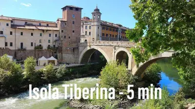 a bridge over a river in front of a building at Khris Home Apartments - Trastevere - San Cosimato in Rome