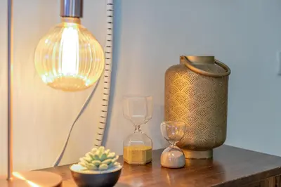 a table with a lamp and two glasses and a vase at Hope Home in Rome