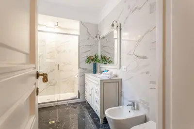 a white bathroom with a sink and a mirror at iFlat Augustus Suite near Pantheon in Rome