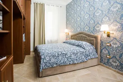 a bedroom with a bed with blue wallpaper at Apartment Glatimia -Your Home In The Heart Of Rome in Rome