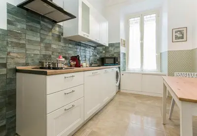 a kitchen with white cabinets and a sink at Apartment Glatimia -Your Home In The Heart Of Rome in Rome