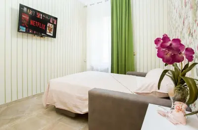 a bedroom with a bed and a vase with purple flowers at Apartment Glatimia -Your Home In The Heart Of Rome in Rome
