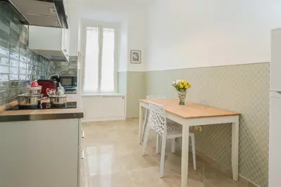 a kitchen with a table with a vase of flowers on it at Apartment Glatimia -Your Home In The Heart Of Rome in Rome