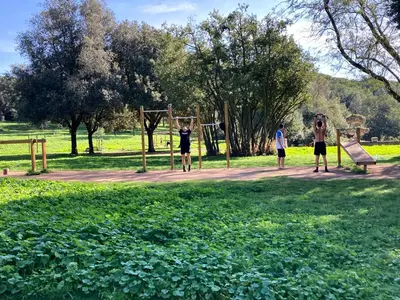 three people playing on a swing set in a park at Ulisse home in Rome