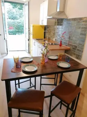 a table in a kitchen with two chairs and plates on it at Art House in Rome