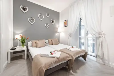 a white bedroom with a bed and a window at Trevi Apartment in Rome