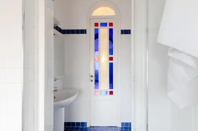 a bathroom with a white door and a sink at Residenza del Cedro in Rome