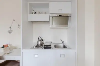 a white kitchen with a sink and a stove at Residenza del Cedro in Rome