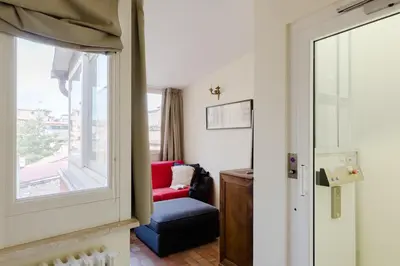 a living room with a red chair and a window at Residenza del Cedro in Rome