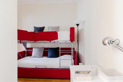a red bunk bed in a room with a desk at Residenza del Cedro in Rome