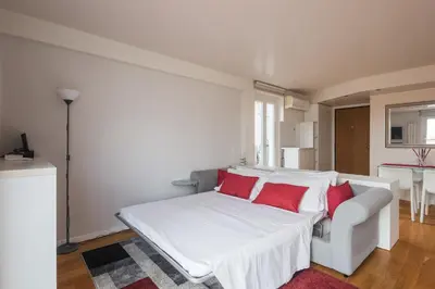 a white bed with red pillows in a room at Appartamento con terrazzo - vicino centro di Roma in Rome