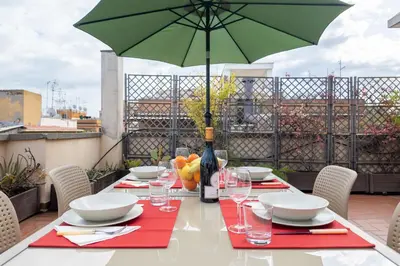a table with a green umbrella on a balcony at Appartamento con terrazzo - vicino centro di Roma in Rome