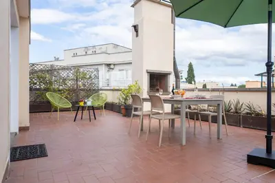 a patio with a table and chairs and a fireplace at Appartamento con terrazzo - vicino centro di Roma in Rome