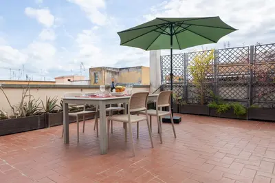 a table and chairs with an umbrella on a balcony at Appartamento con terrazzo - vicino centro di Roma in Rome