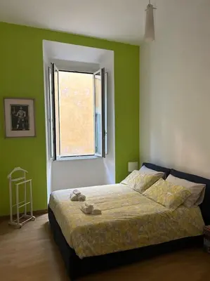 a bedroom with green walls and a bed with a window at Casa di Nonna, Piazza Navona in Rome