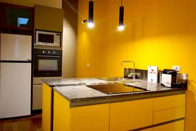 a yellow kitchen with a sink and a microwave at Casa di Nonna, Piazza Navona in Rome
