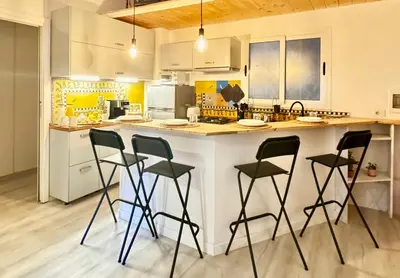 a kitchen with a counter with four bar stools at Appartamento Metro A e Vaticano Maroma in Rome