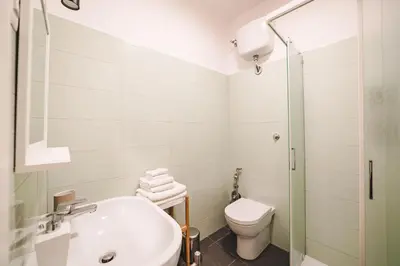 a white bathroom with a toilet and a sink at Cosy Colosseum in Rome
