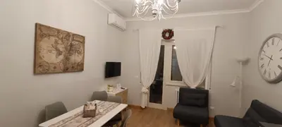 a living room with a table and a clock on the wall at S Peter suite appartamento ristrutturato in centro in Rome