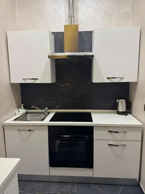 a kitchen with white cabinets and a stove top oven at Gold House Roma in Rome