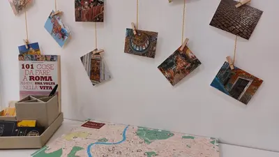 a wall with a map and pictures hanging on it at Way of Saying CASA in Rome