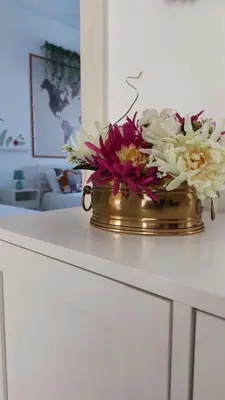 a gold vase filled with flowers on a counter at Way of Saying CASA in Rome