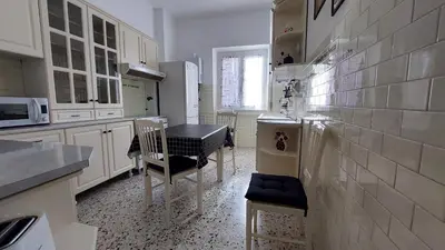 a kitchen with white cabinets and a table and chairs at Way of Saying CASA in Rome