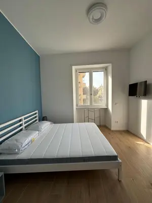 a bedroom with a large white bed and a window at Maison Alteri in Rome