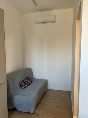 a room with a gray couch with a pillow on it at Maison Alteri in Rome