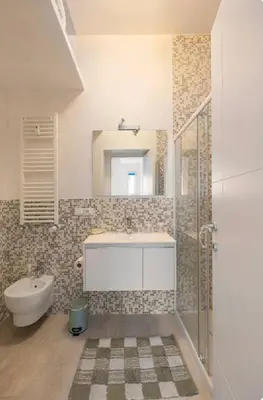 a bathroom with a sink and a toilet and a mirror at luminoso spazio nel barocchetto romano in Rome