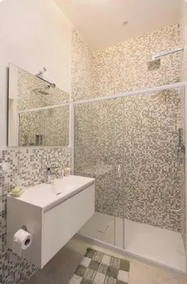 a bathroom with a sink and a glass shower at luminoso spazio nel barocchetto romano in Rome