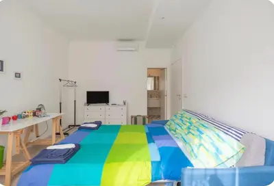 a bedroom with a bed with a colorful blanket at luminoso spazio nel barocchetto romano in Rome