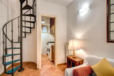 a spiral staircase in a living room with a couch at Charlotte Luxury Home Coronari in Rome